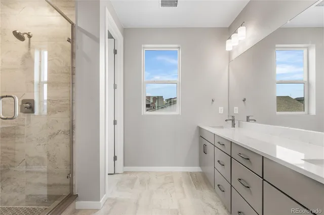 a bathroom with a double vanity sink a mirror and a shower