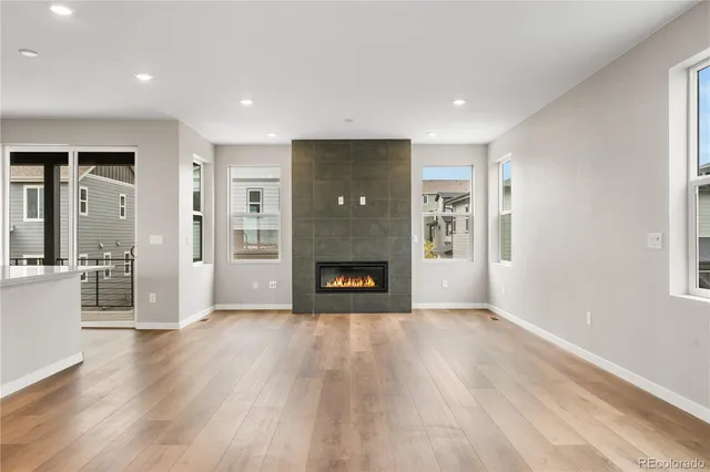 a view of a livingroom with wooden floor and a fireplace