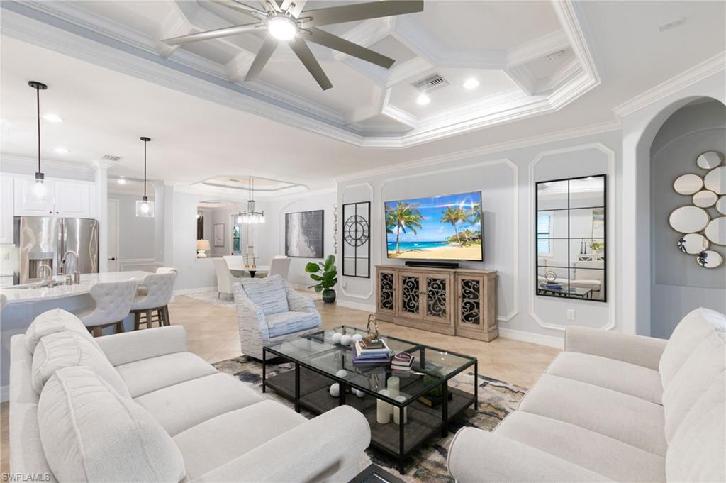 2862 Aviamar Circle Naples, FL 34114 - Photo 17 of 48 Living area featuring coffered ceiling, ornamental molding, beamed ceiling, a chandelier, and light tile patterned floors
