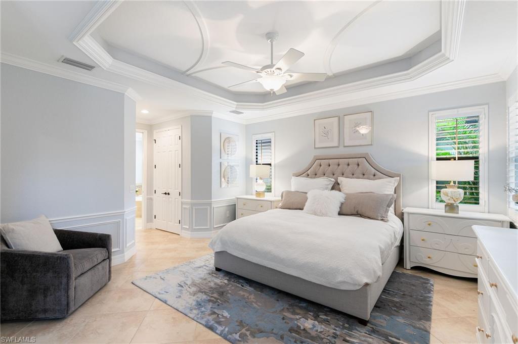 2862 Aviamar Circle Naples, FL 34114 - Photo 18 of 48 Bedroom with a tray ceiling, ornamental molding, a ceiling fan, a decorative wall, and a wainscoted wall
