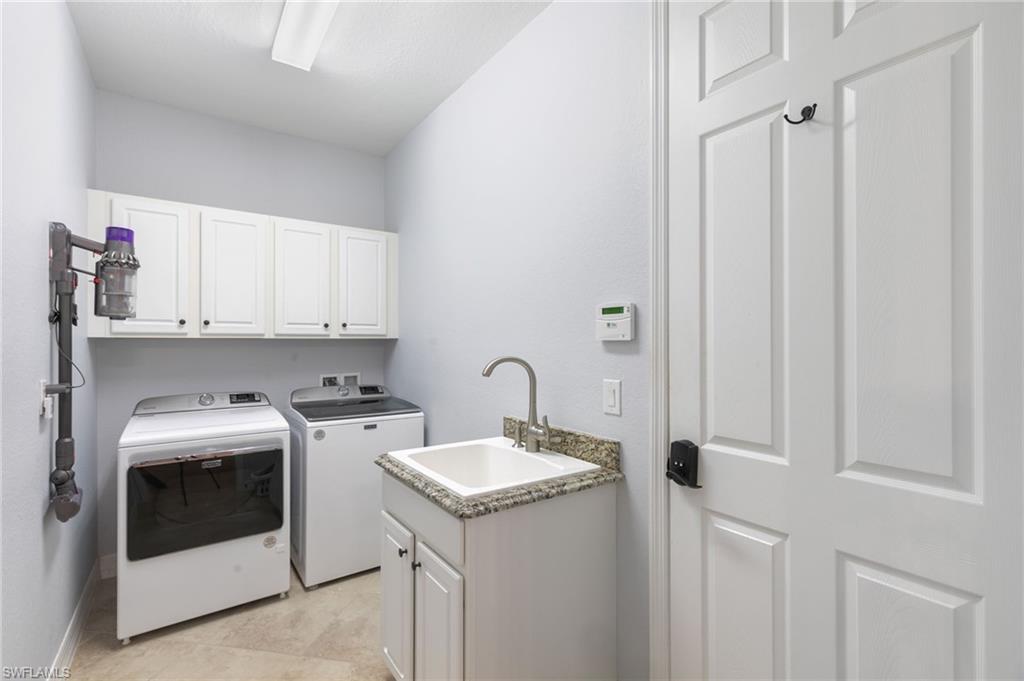2862 Aviamar Circle Naples, FL 34114 - Photo 28 of 48 Laundry area featuring cabinet space, washer and dryer, and light tile patterned floors