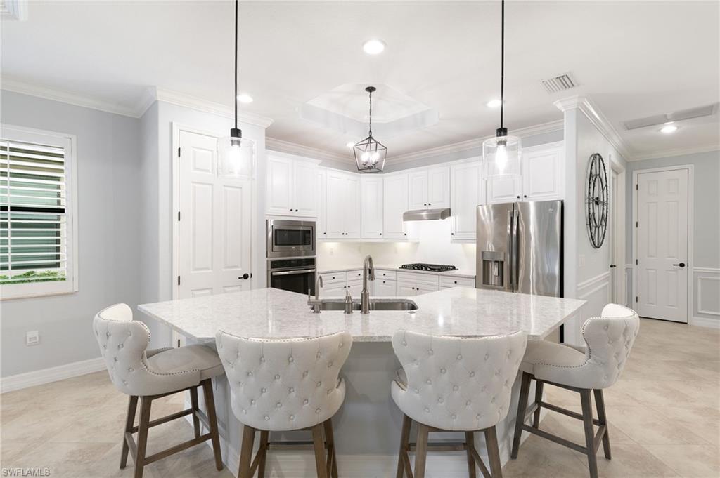2862 Aviamar Circle Naples, FL 34114 - Photo 9 of 48 Kitchen featuring white cabinetry, crown molding, a breakfast bar, recessed lighting, and an island with sink