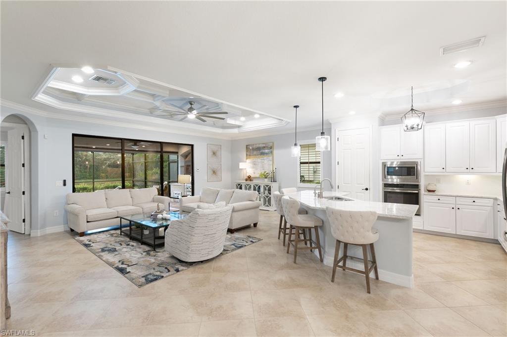 2862 Aviamar Circle Naples, FL 34114 - Photo 10 of 48 Living area featuring ornamental molding, a tray ceiling, recessed lighting, a ceiling fan, and light tile patterned floors