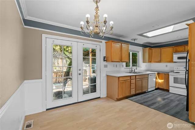 a large kitchen with a window and stainless steel appliances
