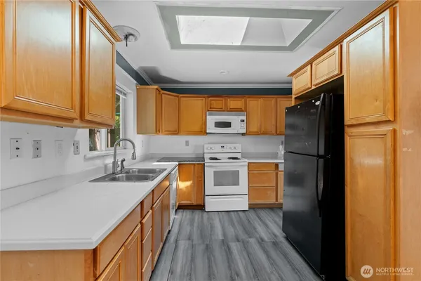 a kitchen with granite countertop stainless steel appliances a refrigerator cabinets and a sink