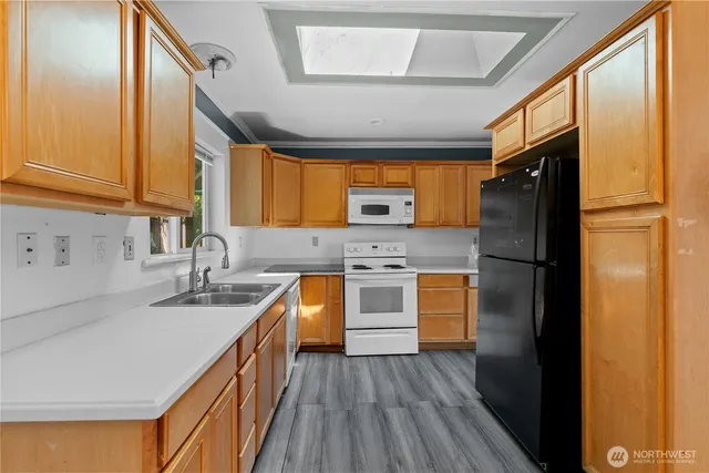 a kitchen with granite countertop stainless steel appliances a refrigerator cabinets and a sink