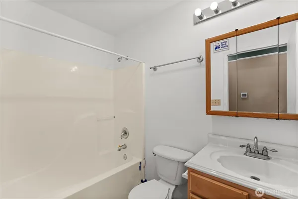 a bathroom with a bathtub shower sink vanity and toilet