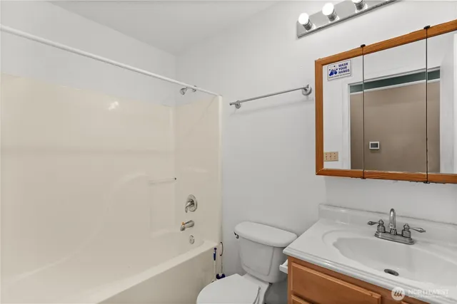 a bathroom with a bathtub shower sink vanity and toilet