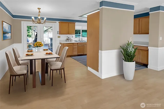 a dining room with furniture a potted plant and a kitchen view