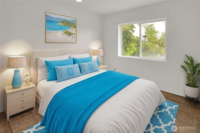 a bedroom with a bed and a painting on the wall