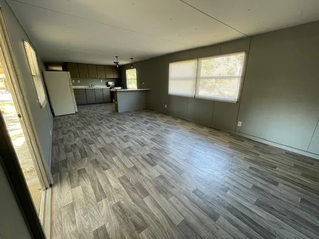 a kitchen with granite countertop a sink a stove and cabinets