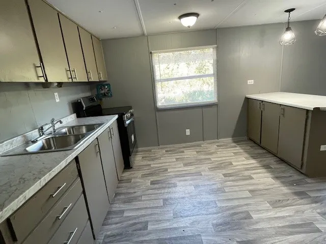 a kitchen with cabinets and wooden floor
