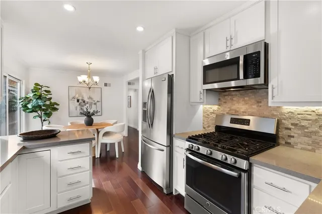 a kitchen with stainless steel appliances a white stove top oven and cabinets