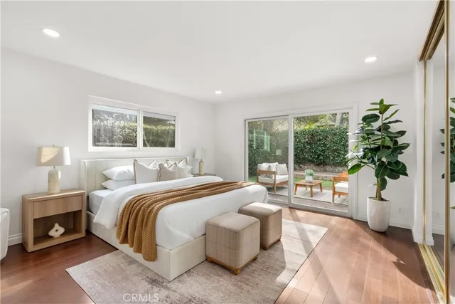 a bedroom with a large bed and a potted plant