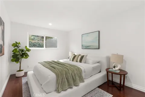 a bedroom with a bed and a potted plant