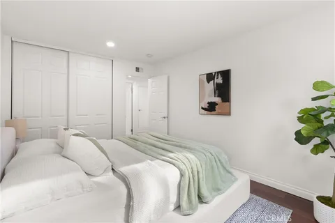 a bedroom with a bed and a potted plant