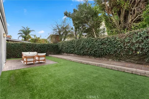 a wooden bench sitting in the grass near a tree