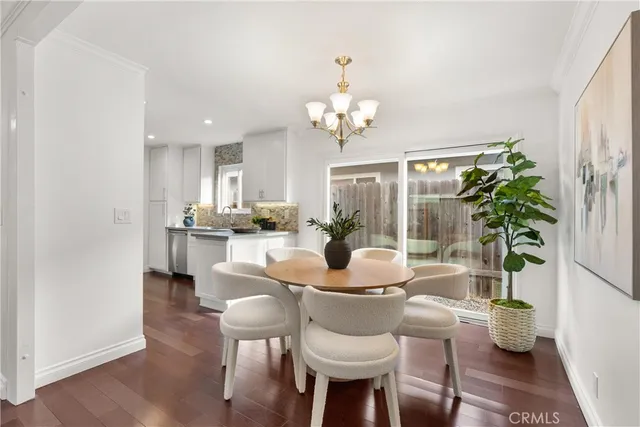 a view of a dining room with furniture a livingroom and chandelier