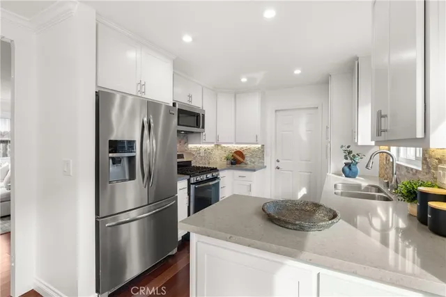 a kitchen with a refrigerator stove and white cabinets