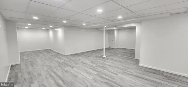 an empty room with wooden floor and natural light