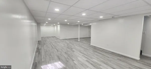 an empty room with wooden floor and natural light