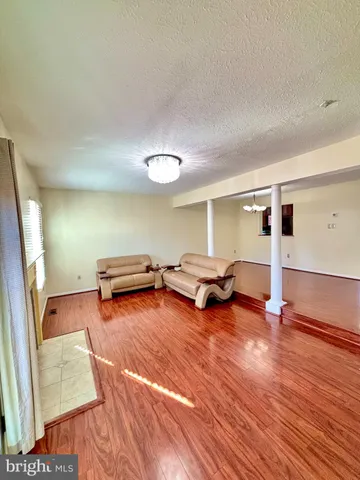 a view of a room with wooden floor and furniture