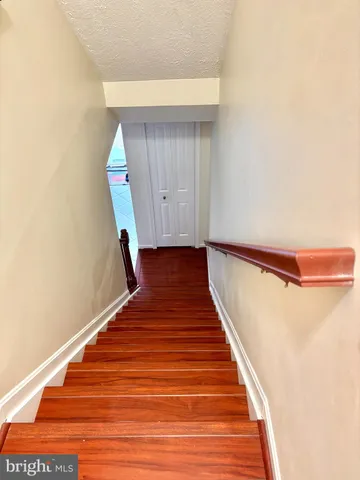 a walk in closet with wooden floor