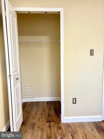 a view of walk in closet with wooden floor