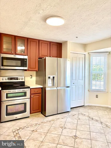 a kitchen with stainless steel appliances granite countertop a refrigerator sink and stove
