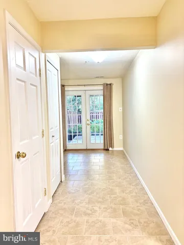 a view of a hallway with wooden floor and a bathroom