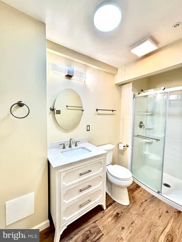 a bathroom with a granite countertop sink mirror vanity and toilet