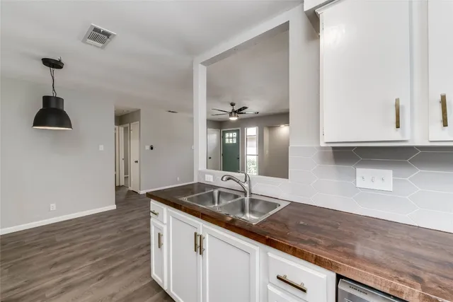 a kitchen with granite countertop a sink and a wooden floor