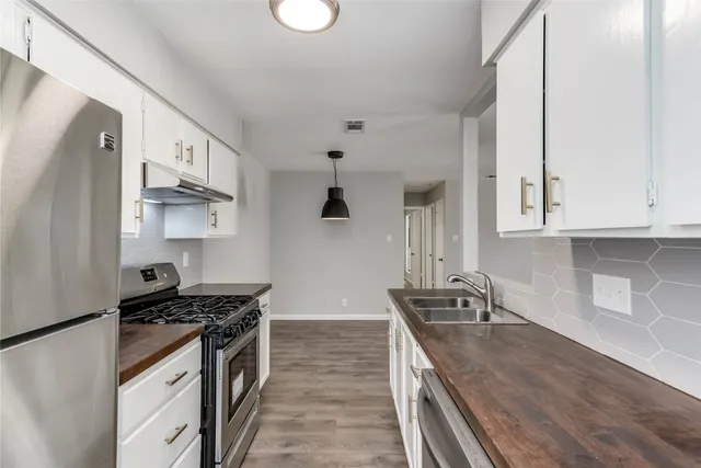 a kitchen with granite countertop a sink stove and refrigerator