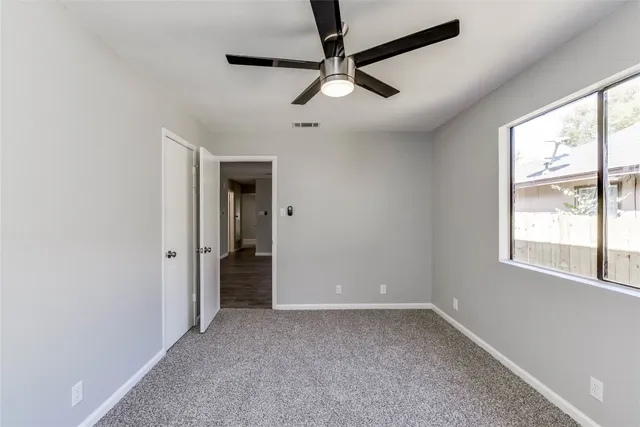 a view of a livingroom with a ceiling fan and window