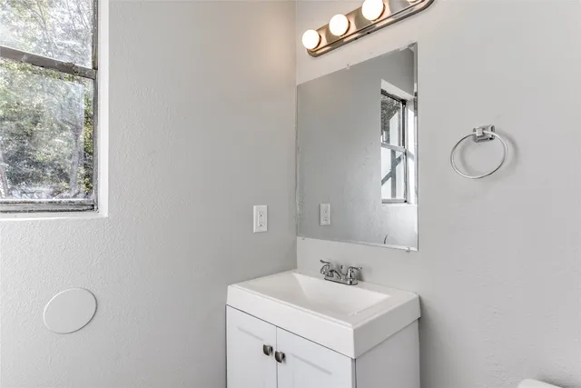 a bathroom with a toilet sink vanity and mirror
