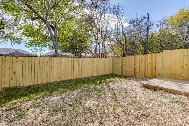 a view of a backyard with wooden fence