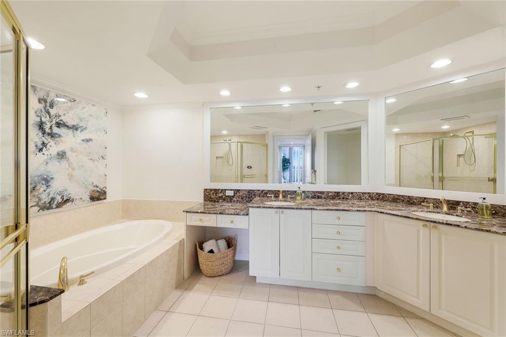 1060 Borghese Lane, Unit 2002 Naples, FL 34114 - Photo 12 of 22 a bathroom with a bathtub a sink a toilet a mirror and vanity