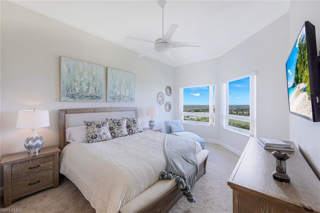 1060 Borghese Lane, Unit 2002 Naples, FL 34114 - Photo 15 of 22 a bedroom with a large bed and a flat tv screen on dresser