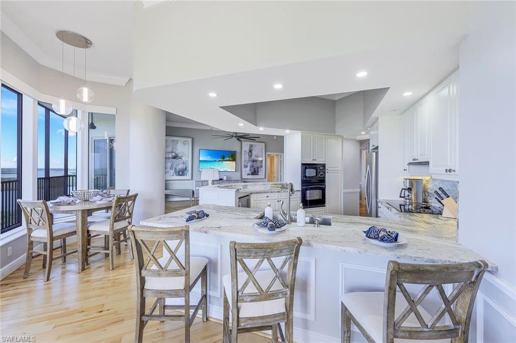 1060 Borghese Lane, Unit 2002 Naples, FL 34114 - Photo 6 of 22 a view of a dining room with furniture and wooden floor