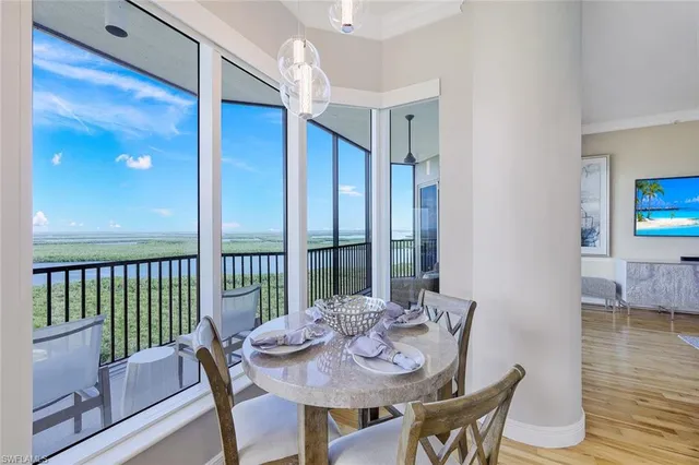 a view of a dining room with furniture a chandelier and wooden floor