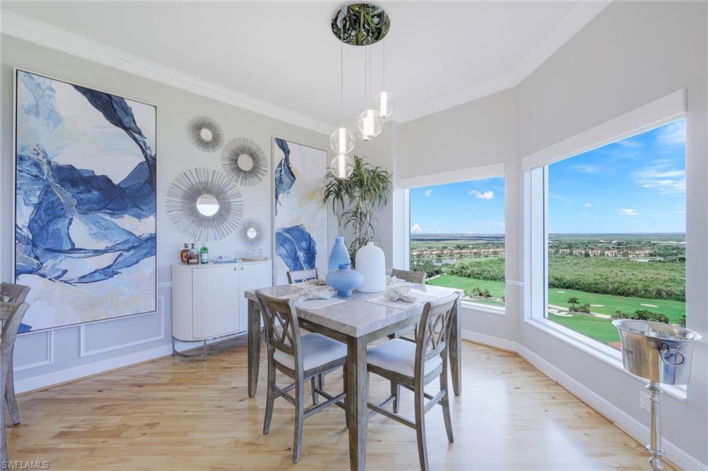 1060 Borghese Lane, Unit 2002 Naples, FL 34114 - Photo 9 of 22 a view of a dining room with furniture a chandelier and wooden floor