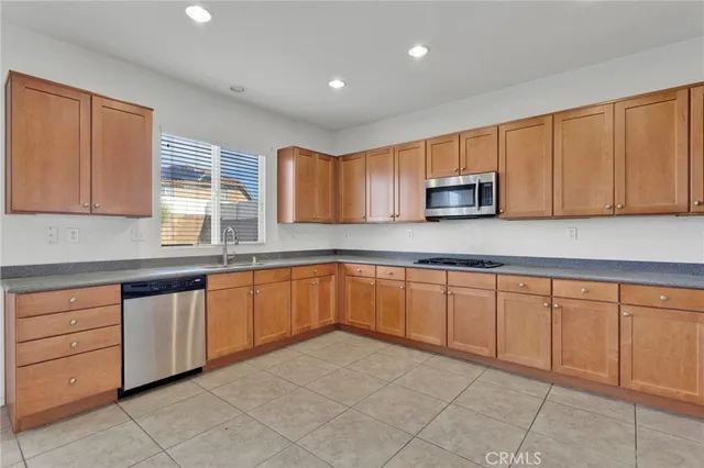 a kitchen with granite countertop a sink cabinets and stainless steel appliances