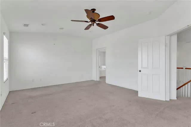 a view of a livingroom with a ceiling fan and window