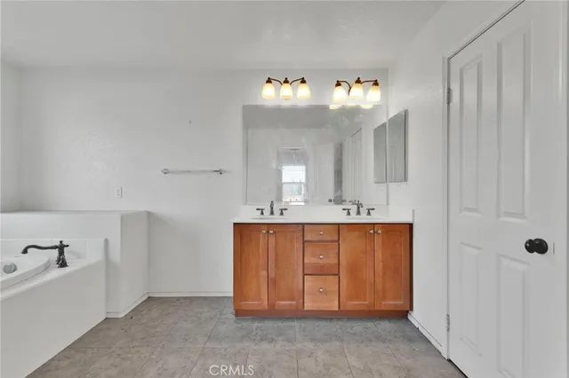 a spacious bathroom with a tub sink and mirror