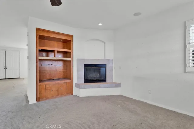 an empty room with a fireplace and cabinet