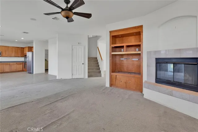 a view of an empty room with a fireplace and a window