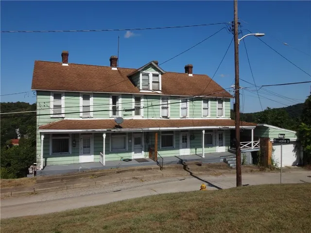 a front view of a building with a garden