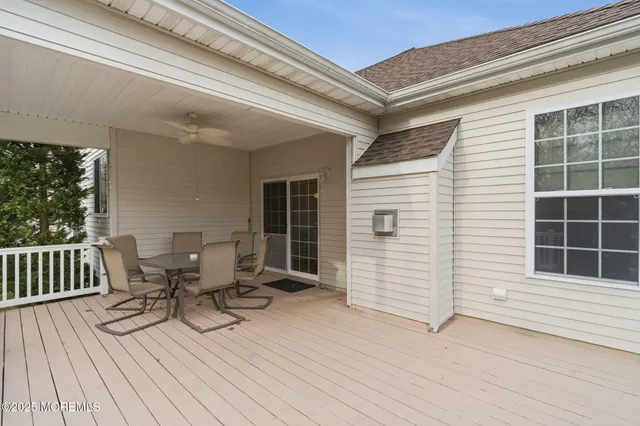 a view of a deck with table and chairs with wooden floor and fence and a window