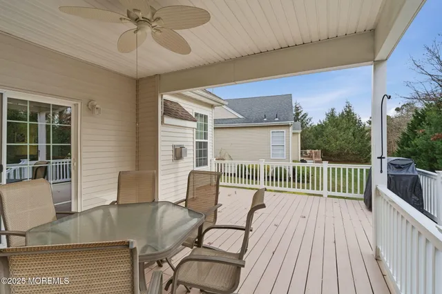 a view of a deck with table and chairs with wooden floor and fence