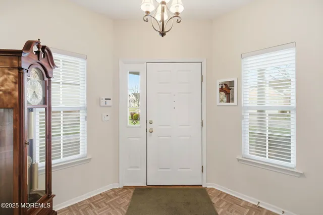 a view of empty room with window and wooden floor